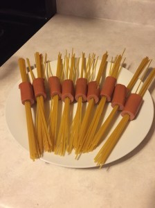Here is the spaghetti, threaded with hot dogs. In addition to cutting the hot dogs smaller, I would also only put about four pieces of spaghetti through each one. The more spaghetti in the hot dog, the less it cooked (though I suspect having smaller pieces of hot dog would also help this problem).